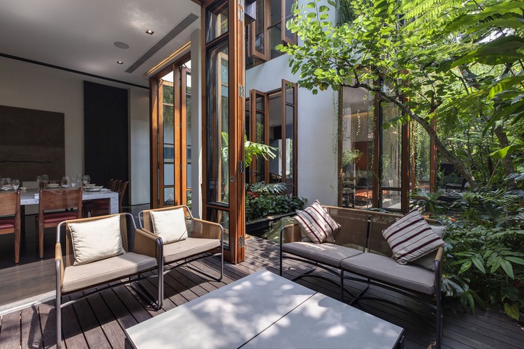 Merryn Road Architects Beautiful Merryn Road House Aamer Architects Deck Involving Brown Sofa Chairs And White Coffee Table Exterior  Impressive Compact House Covered With Green Plants Exterior 