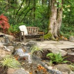 Open Space Including Exciting Open Space Lounge Corner Including Wooden Chair On Rough Stoney Ground Also Rocks Waterfall With Trees And Plants At Backside Garden  Backyard Garden Waterfalls As Beautiful Garden Landscaping 