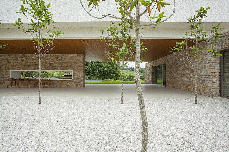 Trees On Itatiba Small Trees On GRavels At Itatiba Residence Roccovidal Garden Open Space To Kitchen Applied Wood Stools And Stone Wall Interior Design  Warm Interior Design From A Modern Home With Dim Lighting 
