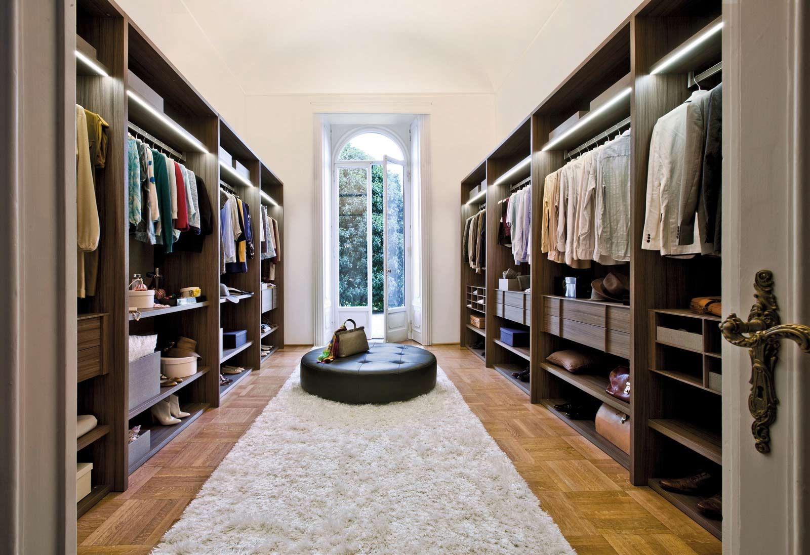 Walk In Applying Admirable Walk In Closet Ideas Applying Wooden Flooring Completed With Clothes Rack And Cabinet Lighting Also Furnished With Black Tufted Round Chair On White Soft Rug Closet Walk In Closet Ideas: Enjoying Private Collection