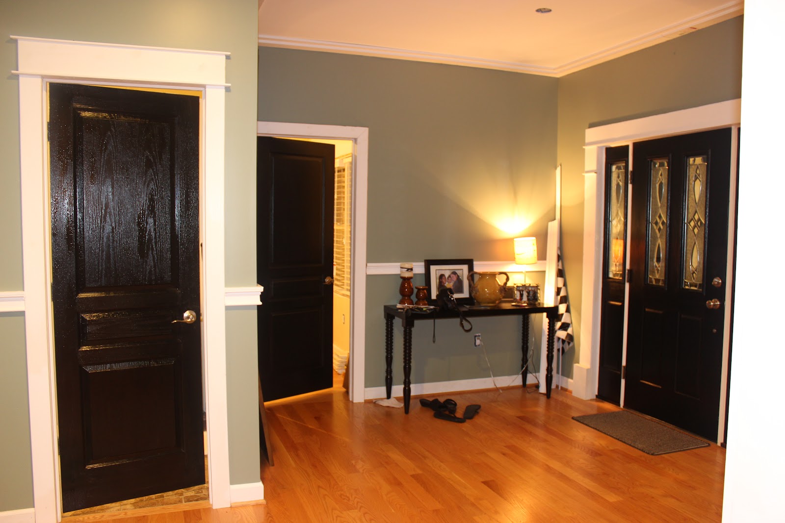 Entrance With Combined Captivating Entrance With Wooden Flooring Combined With Black Interior Doors Furnished With Table Completed With Table Decorations Plus Added With Table Lighting Interior Design Black Interior Doors And Its Elegant Appearance