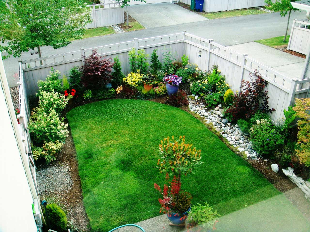 Backyard Landscape Colorful Small Backyard Landscape Design Using Colorful Flower And Green Garden Completed With White Wooden Fence Design Outdoor Backyard Landscape Design To Make The Most Of Your Space